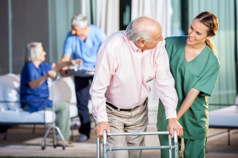A nurse assisting a man with a walker
