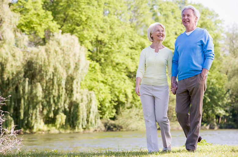 Senior couple walking together on a secure path in an active living community